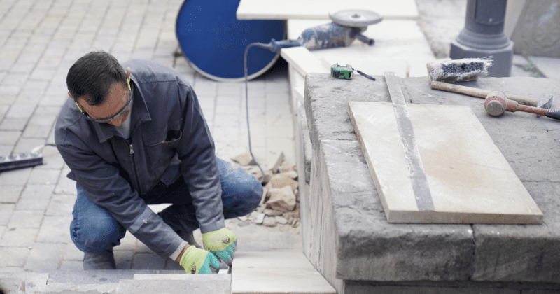 Image of a man installing a masonry walkway for those looking to start your outdoor service business.